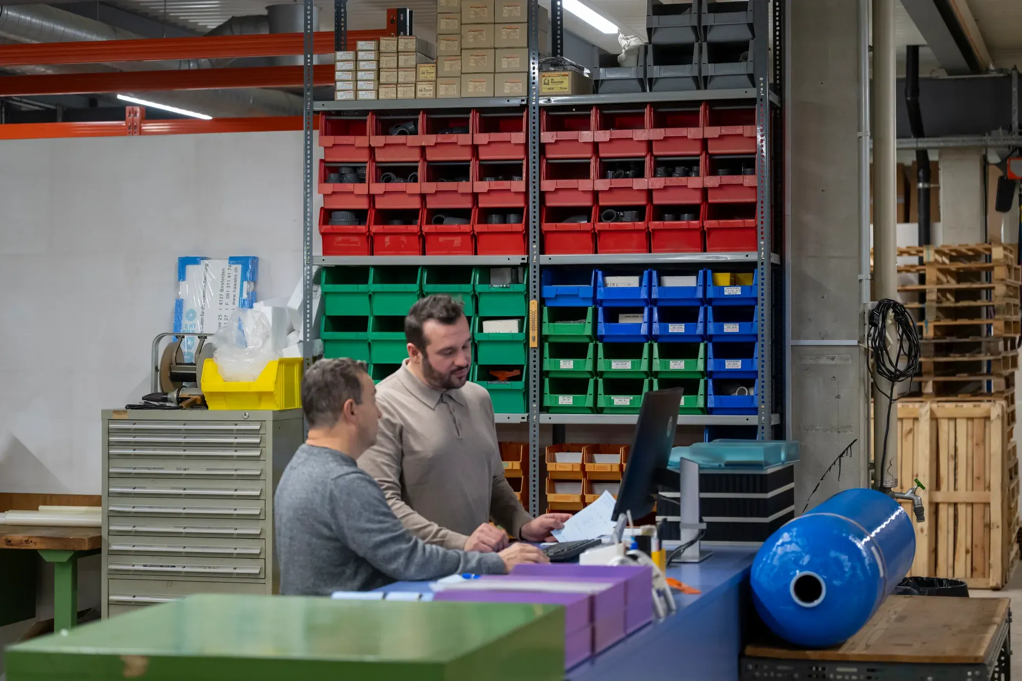 Poste de travail devant le stock de pièces de rechange chez Hawako